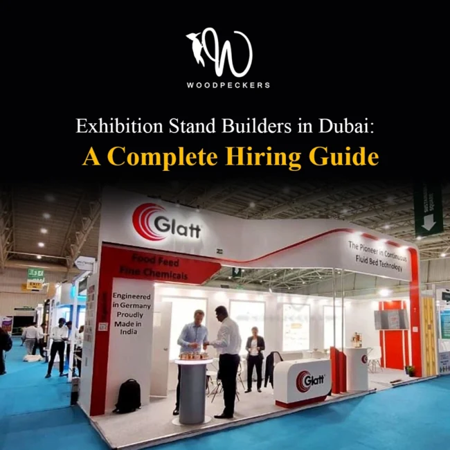Custom trade show booth fabricated by Woodpeckers for Glatt, featuring modern curved overhead fascias, red and white corporate branding, backlit poster panels, and client meeting counters.
